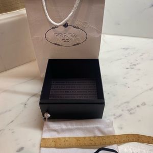 White Prada shopping bag with black jewelry case and more